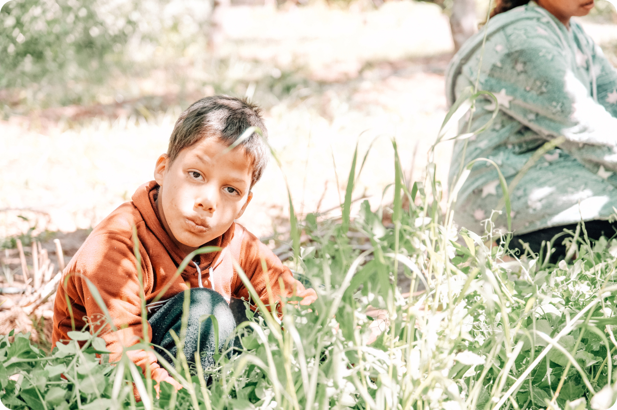 Enfant du Centre Fiers et Forts dans le jardin de permaculture