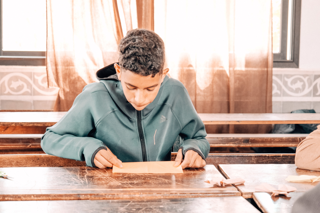 Enfant du Centre Fiers et Forts avec une feuille de papier en main